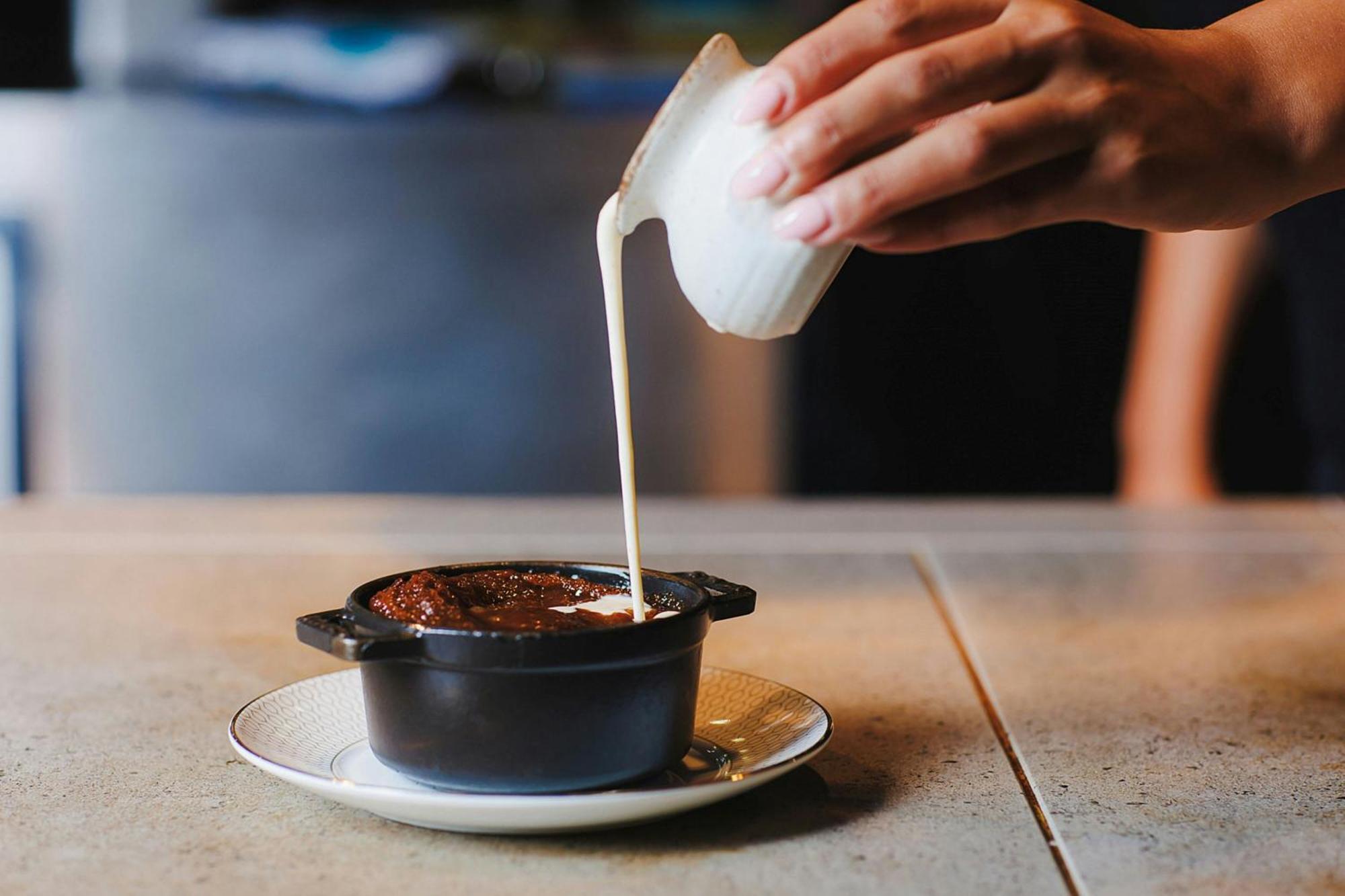 Stock Exchange Hotel, Manchester, Autograph Collection Luaran gambar A pot of chocolate pudding being topped with cream